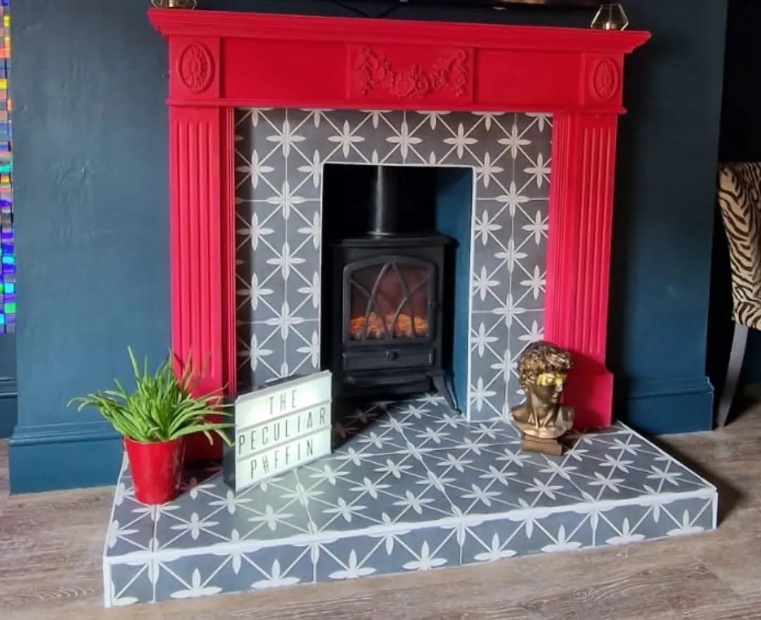 Tiled fireplace hearth and surround with a stove and red mantel