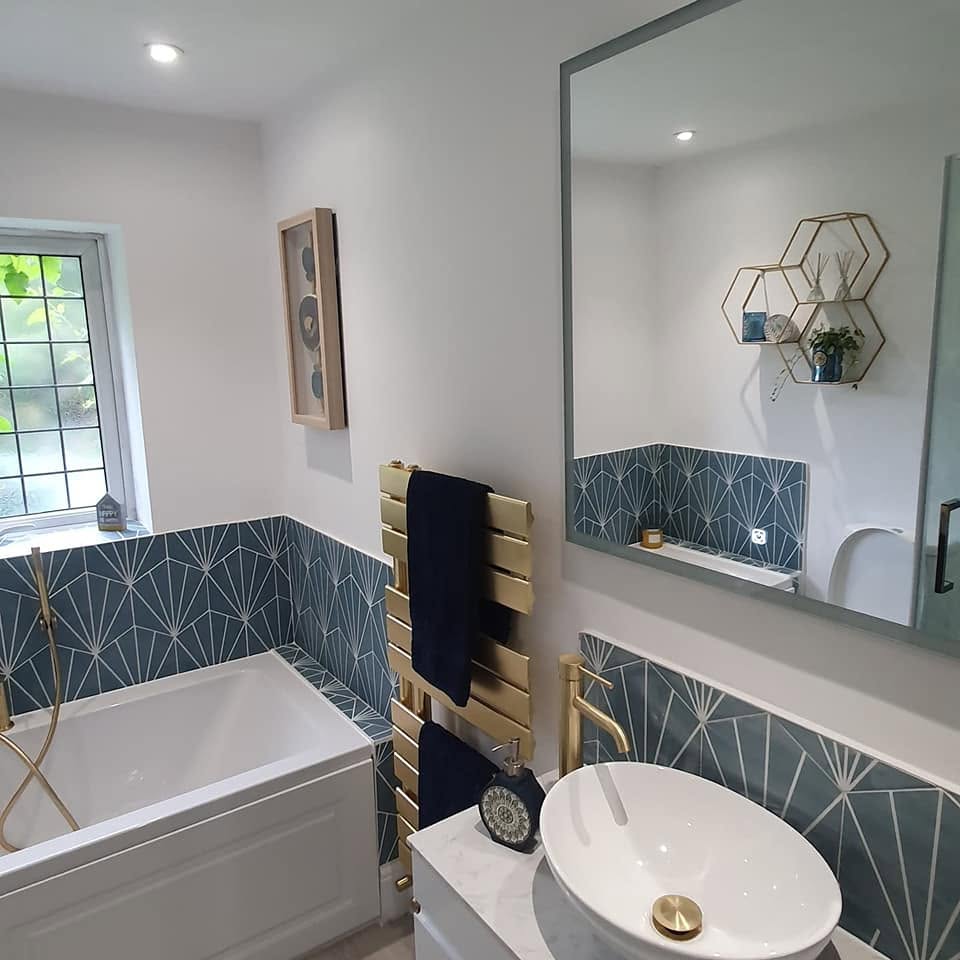 Teal fan-tiled bath surround with a gold towel rail and a white vessel basin