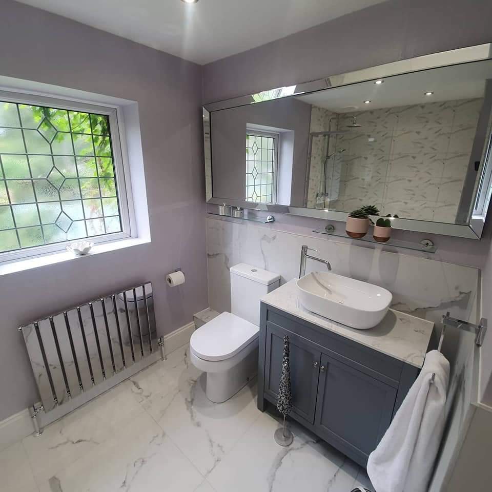 Lilac bathroom with marble-effect floor, grey vanity unit and chrome column radiator