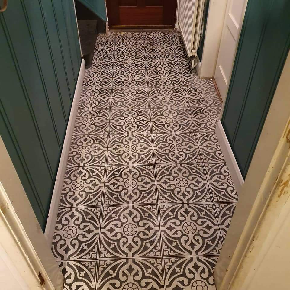 Hallway laid with black and white patterned floor tiles