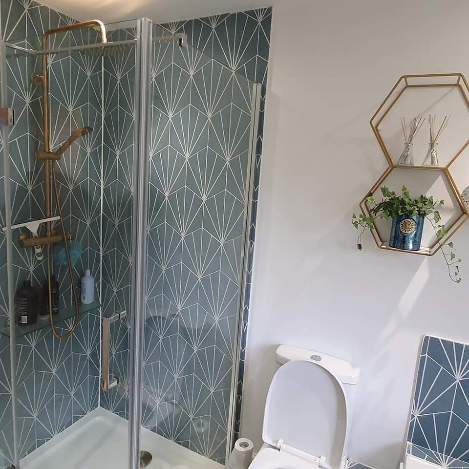 Shower with teal fan-pattern tiles and a brushed gold shower set